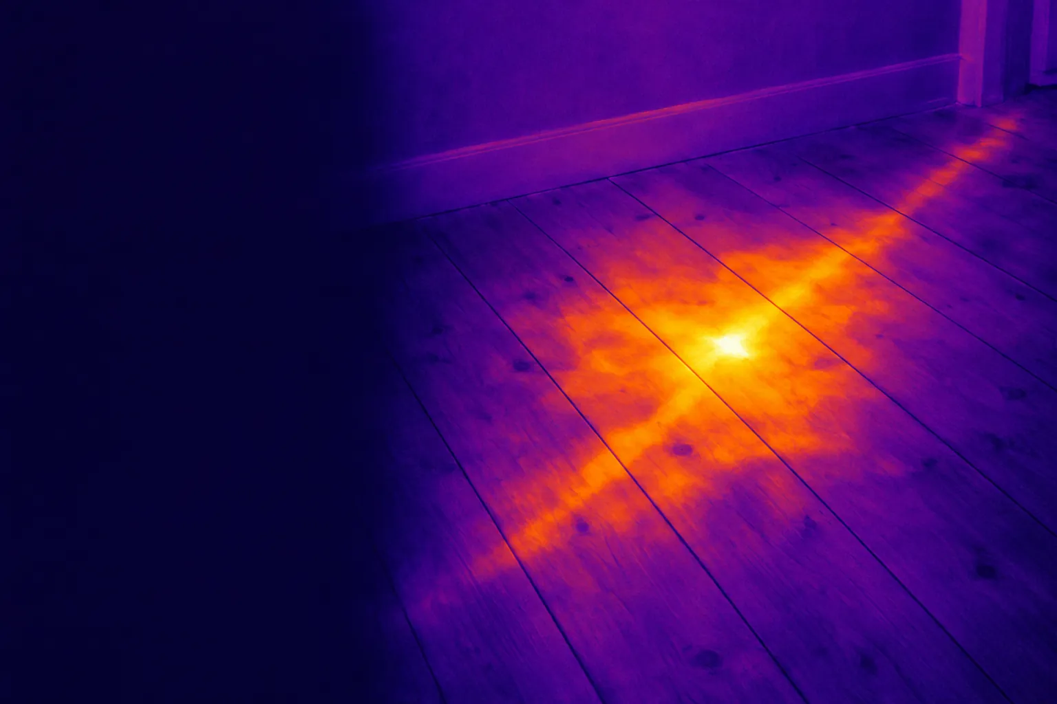 Thermal illustration of a hot water pipe leaking under floorboards, the pipe run showing through the boards